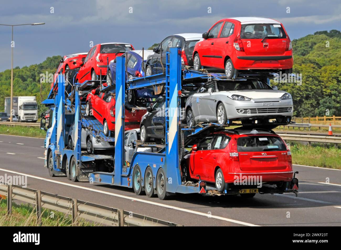 car-transporter-hgv-lorry-truck-prime-mover-semi-articulated-trailer-loaded-with-new-cars-driving-along-m25-orbital-motorway-road-essex-england-uk-2WKF23T.jpg